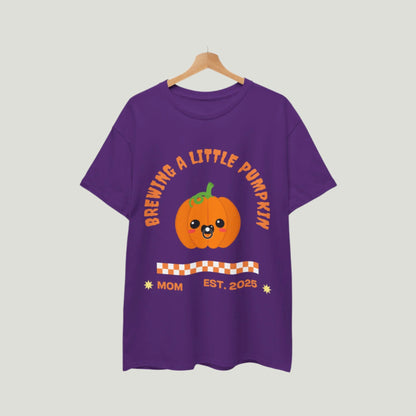 Purple Brewing A Little Pumpkin T-Shirt featuring an adorable pumpkin with a pacifier and the text "Brewing a Little Pumpkin, Mom Established 2025." This charming and comfortable tee is perfect for announcing a pregnancy during Halloween, making it a delightful choice for expecting parents. Ideal for festive celebrations, family gatherings, and capturing memorable photos!