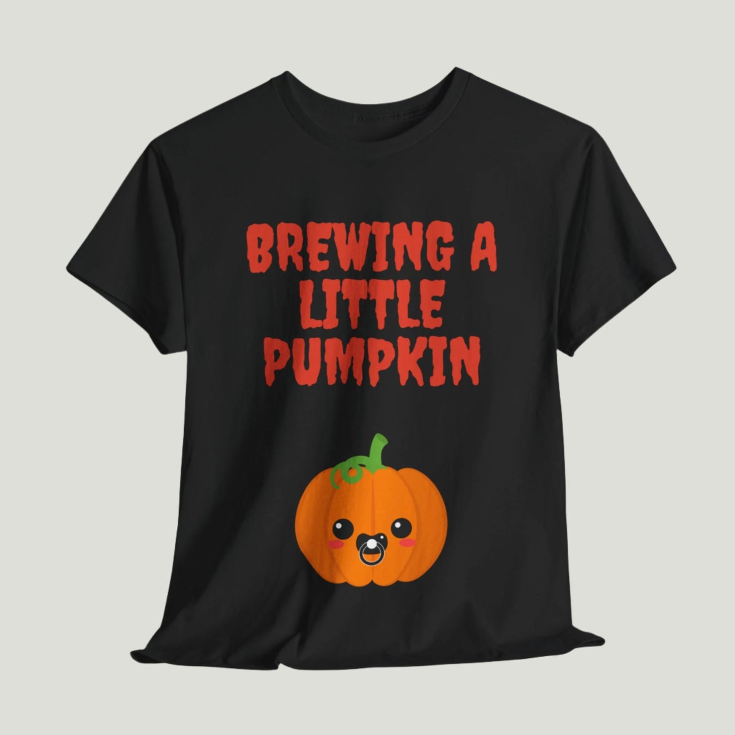 Black t-shirt featuring red text "Brewing A Little Pumpkin," perfect for announcing a pregnancy during Halloween, worn by a smiling woman.