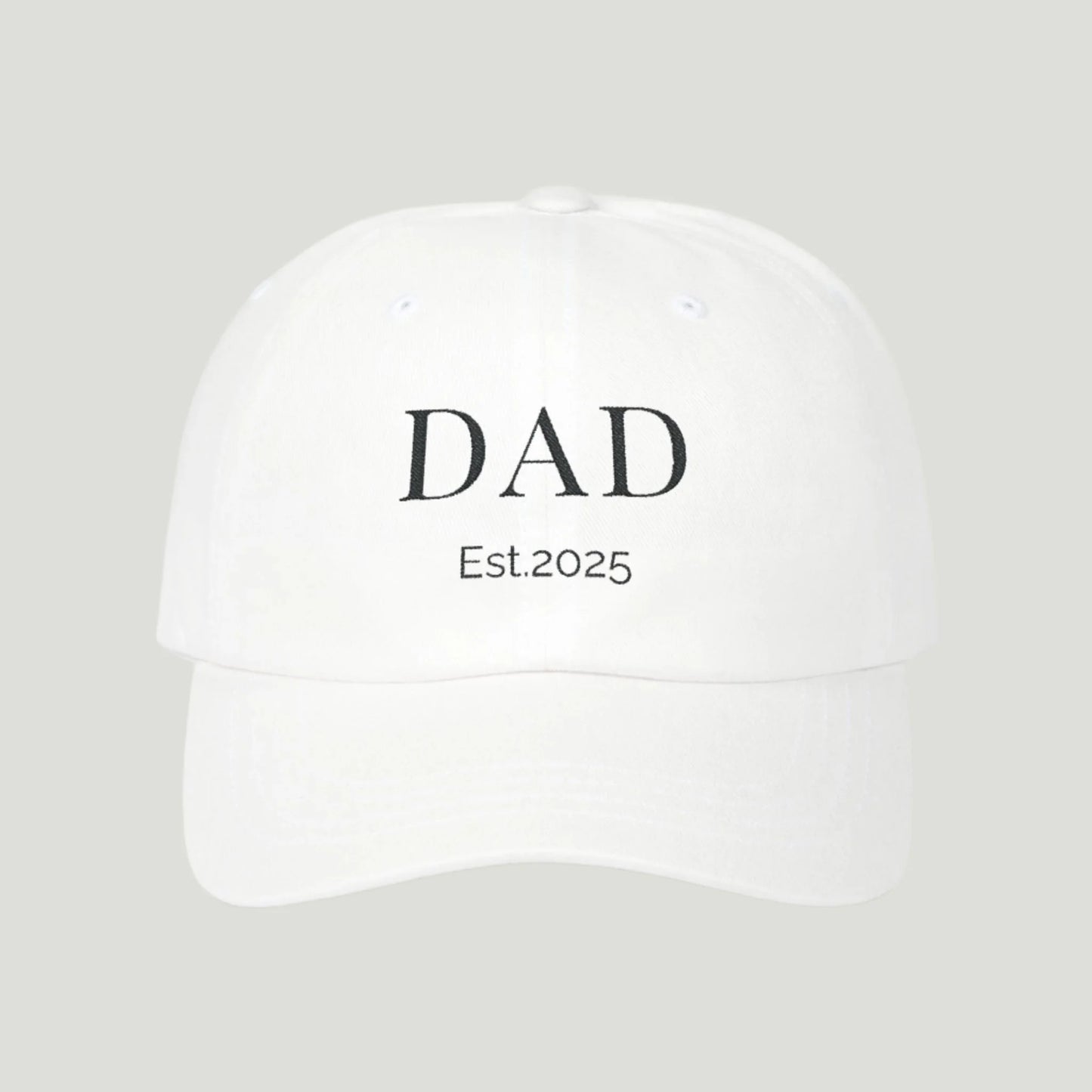 Classic Dad Cap in white color. Stylish design featuring the word "Dad Established 2025" embroidered in black thread. This cap makes an ideal gift for announcing a pregnancy to dads-to-be, combining practicality and sentimentality for a memorable reveal. Perfect for everyday wear or special occasions!