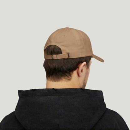 Classic Dad Cap in khaki color. Stylish design featuring the word "Dad Established 2025" embroidered in black thread. This cap makes an ideal gift for announcing a pregnancy to dads-to-be, combining practicality and sentimentality for a memorable reveal. Perfect for everyday wear or special occasions! Back view worn by a man