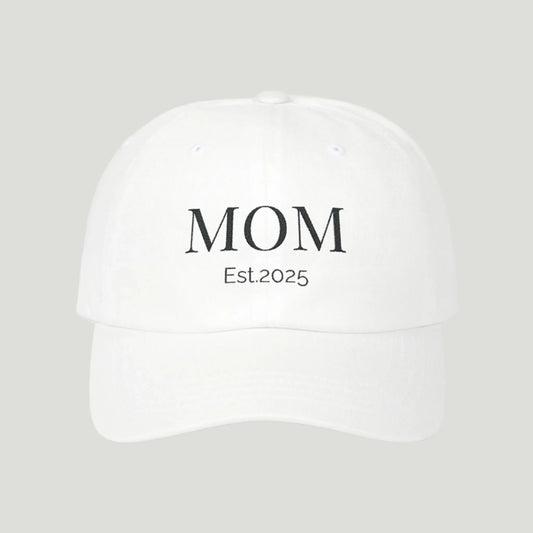 Classic Mom Cap in white color, featuring a stylish embroidered 'Mom' design in black thread, perfect for celebrating motherhood and announcing pregnancy.