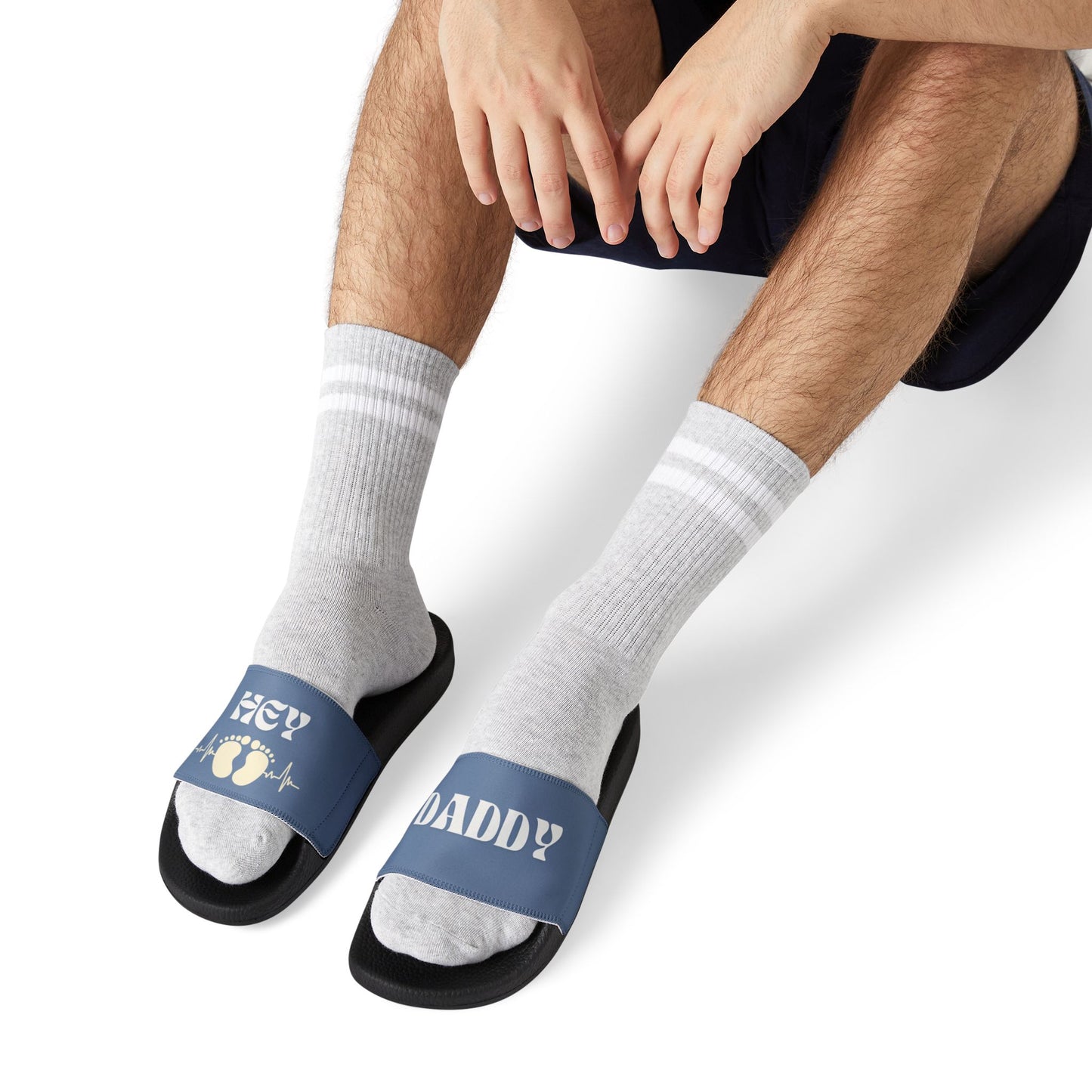 Man wearing Hey Daddy Sandals with black sole and  navy blue strap and letters in white.