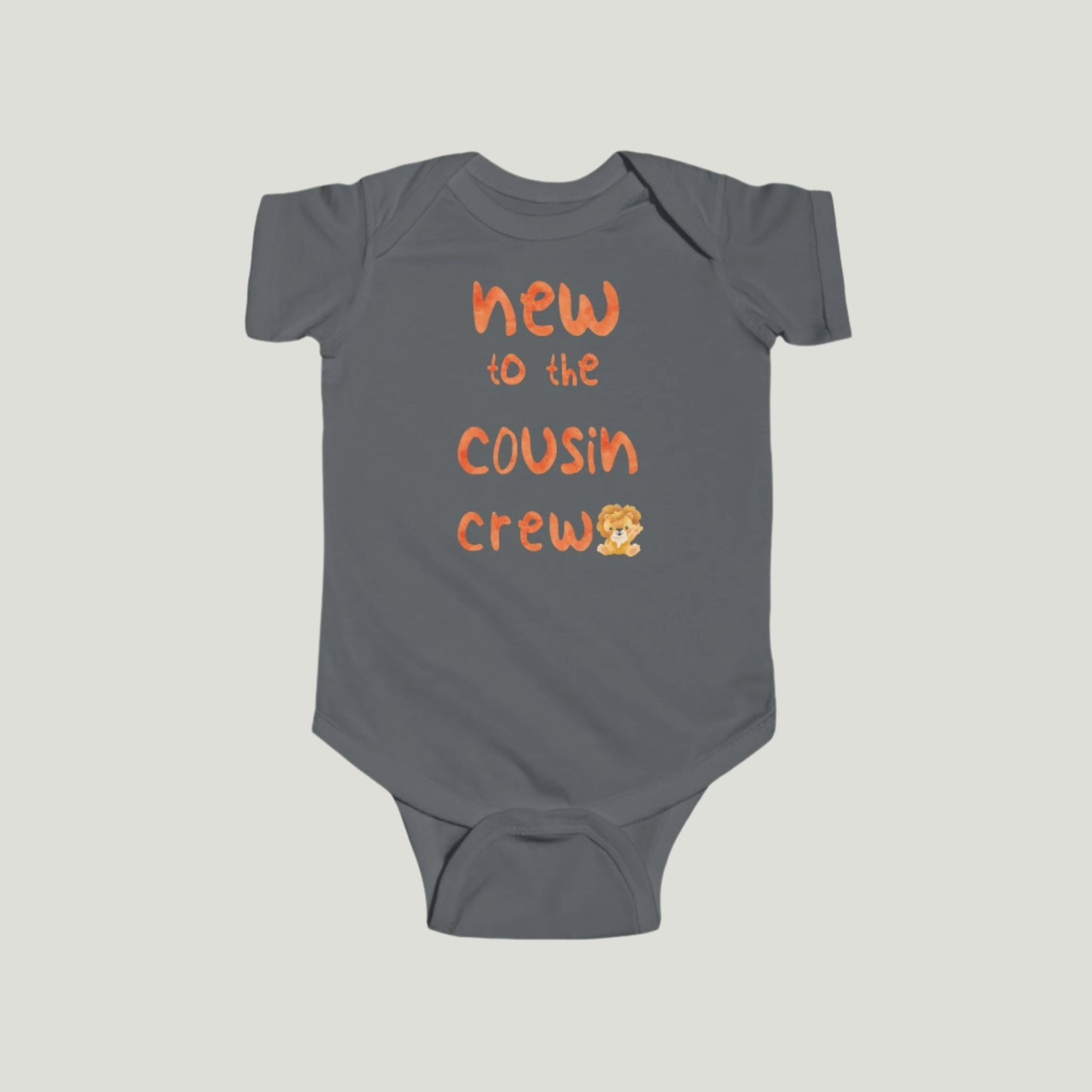 Charcoal color  baby onesie featuring orange text that reads "New to the Cousin Crew," perfect for announcing a pregnancy to family and friends