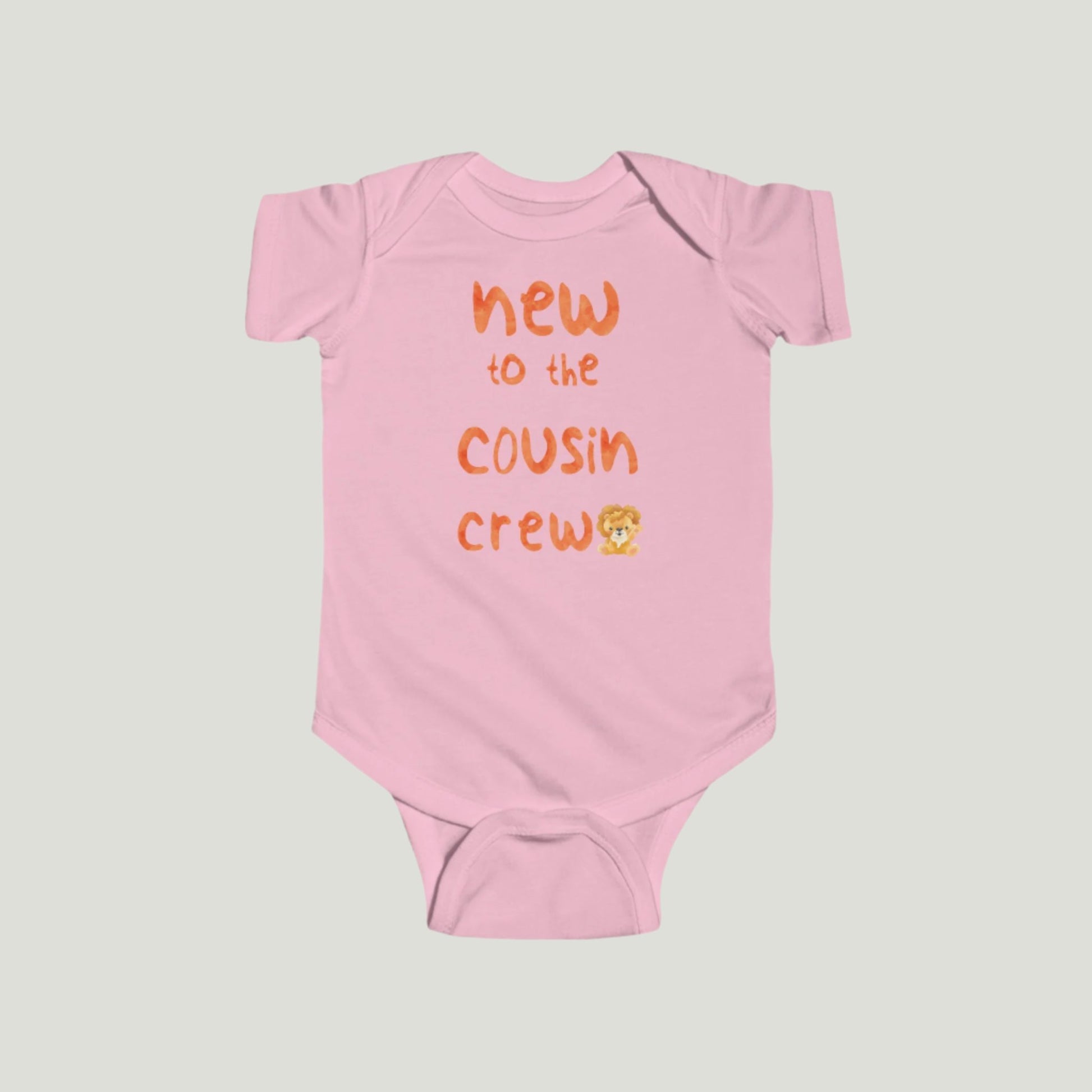 Pink baby onesie featuring orange text that reads "New to the Cousin Crew," perfect for announcing a pregnancy to family and friends