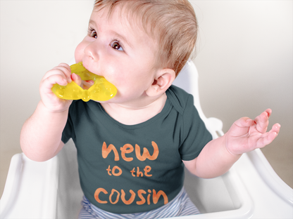 Smiley baby wearing Navy baby onesie featuring orange text that reads "New to the Cousin Crew," perfect for announcing a pregnancy to family and friends